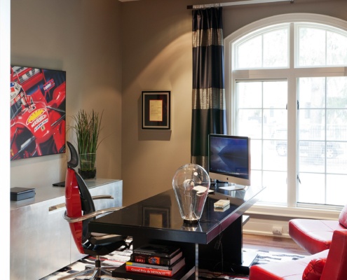 Home office with hardwood floor, arched window and white frame windows.