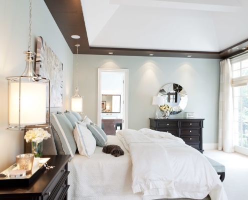 Master bedroom with beige carpet, wood ceiling and white frame windows.