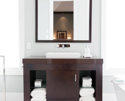 Master bathroom with tile floor, white frame windows and wood vanity.