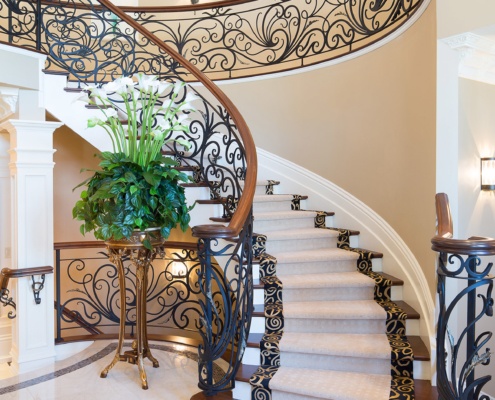 Spiral staircase with white columns, carpet treads and white trim.