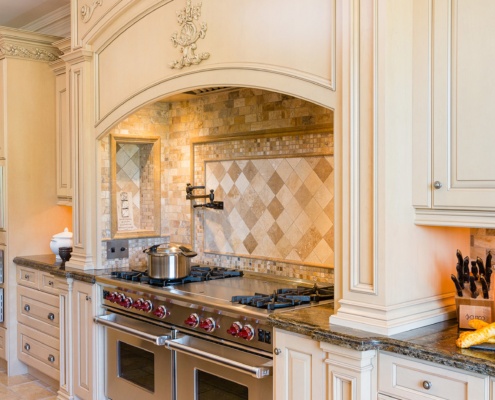 Ornate kitchen with granite countertops, tile backsplash and tile floor.