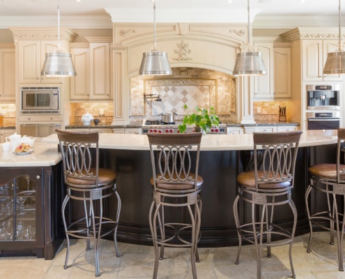 Kitchen with large island, breakfast bar and tile backsplash.