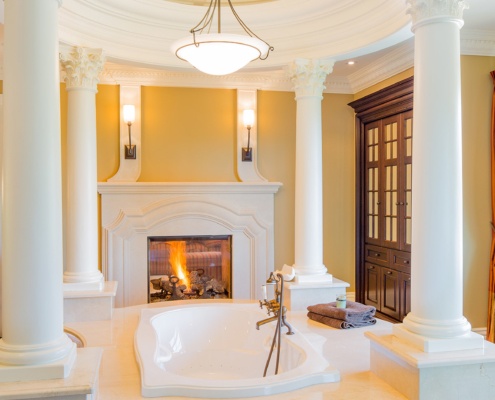 Master bathroom with stone fireplace, stone column and wood cabinet.