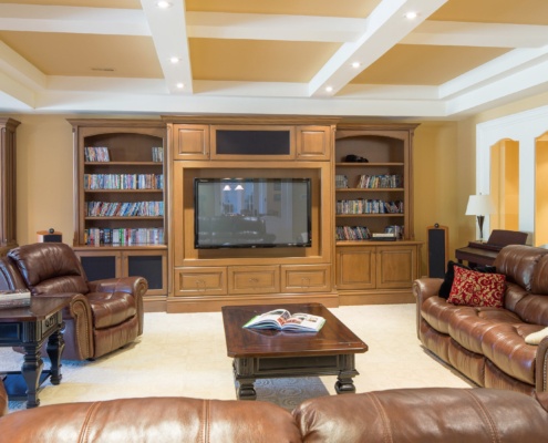 Family room with white carpet, built in shelves and white trim.