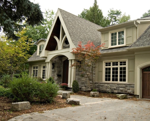 Traditional home with large gable, stucco siding and white frame windows.
