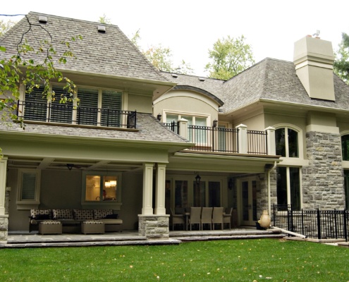 Home design with covered stone porch, basement walkup and stucco columns.