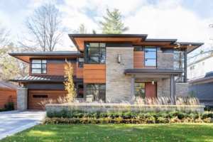 Natural modern home with floating roof, sconce lighting and stone columns.