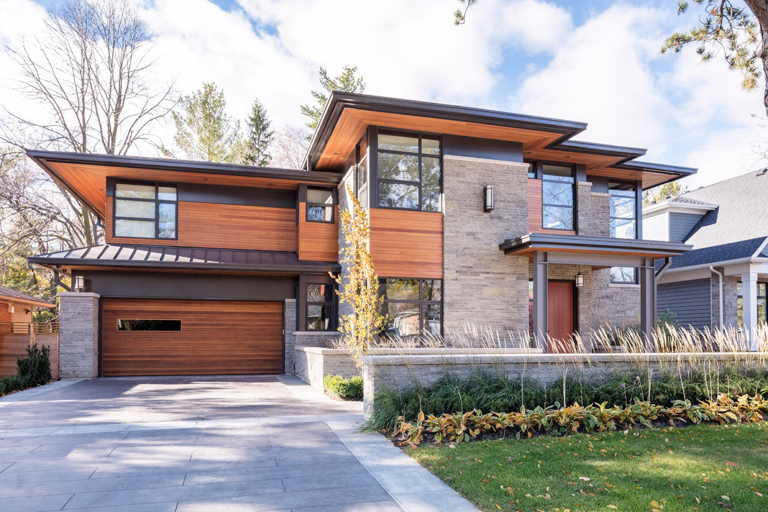 Oakville house with large overhang, metal roof and steel columns.