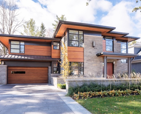 Oakville house with large overhang, metal roof and steel columns.