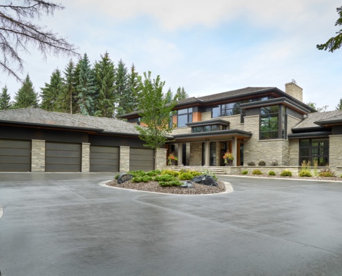 Contemporary house with black frame window, steel columns and circular driveway.