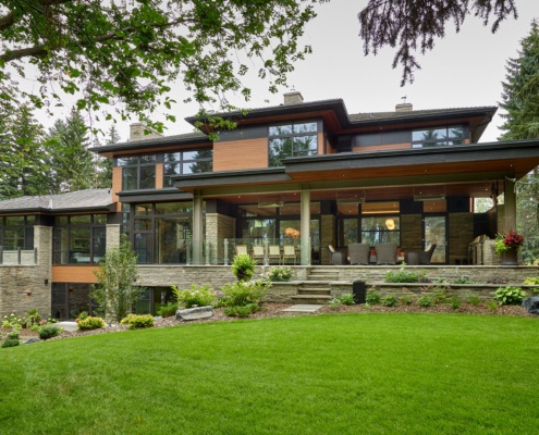 Natural modern house iwth flaoting roof, wood siding and covered stone deck.