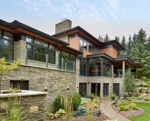 Edmonton house with natural stone, glass railing and corner window.