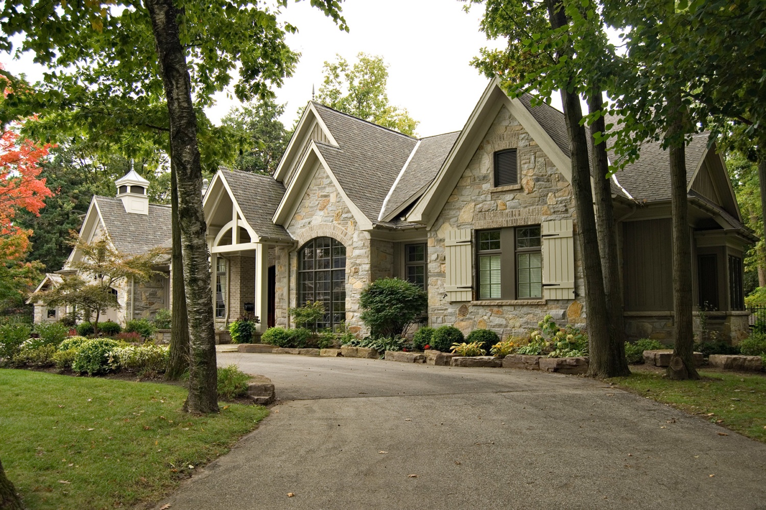 Traditional home with natural stone, beige colour scheme and circular driveway.