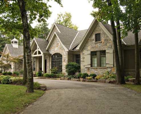 Traditional home with natural stone, beige colour scheme and circular driveway.