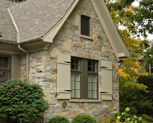 Traditional home with gabled roof, shutters and natural stone.