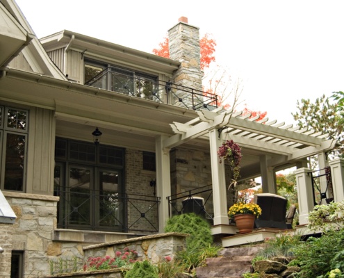 Traditional home with second floor balcony, stone chimney and wood siding.