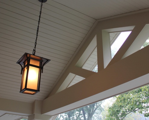 House front entry with hanging light, wood ceiling and white trim.