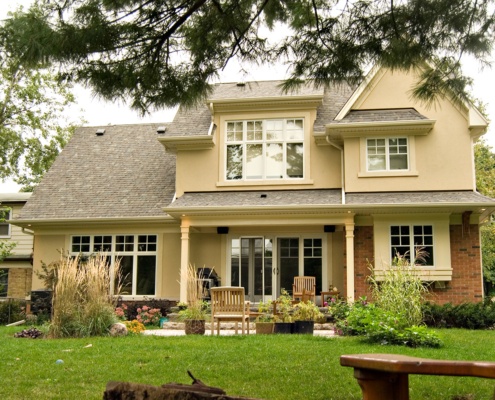 Traditional house with red brick, stucco siding and white frame windows.