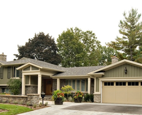 Traditional home design with wood siding, beige trim and landscape wall.