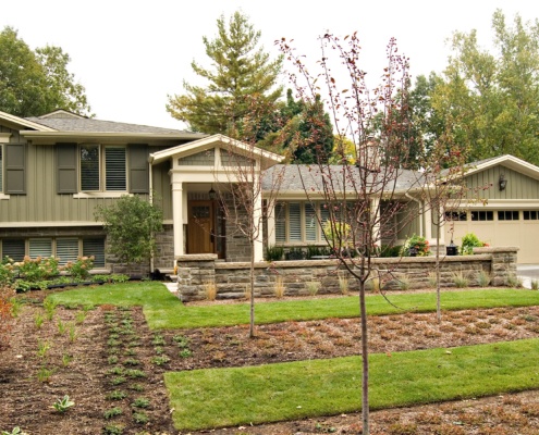 Mississauga renovation with wood siding, natural stone and shutters.