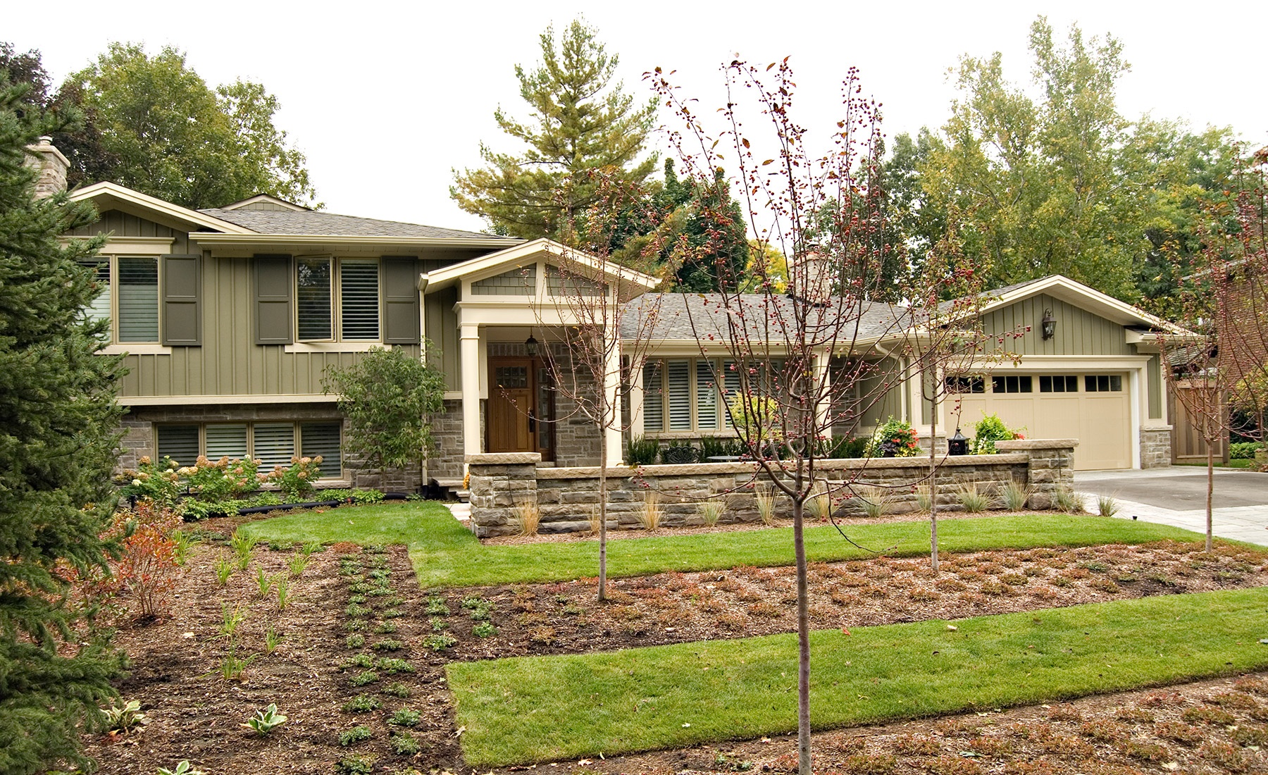 Mississauga renovation with wood siding, natural stone and shutters.