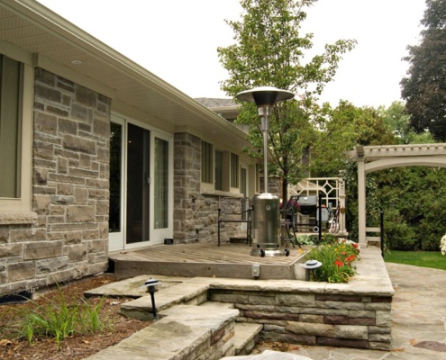 Home renovation with natural stone, white eaves and wood siding.