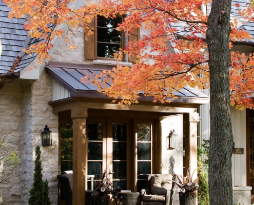 Backyard deck with metal roof, wood shutters and large gable.