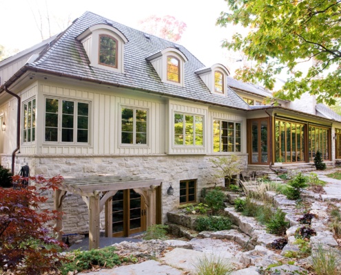 Home exterior with stone wall, beige window and wood door.