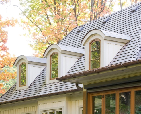 Traditional style home with wood shingles and copper eaves.