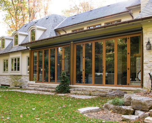 Mississauga home with floor to ceiling glass, natural stone and wood siding.