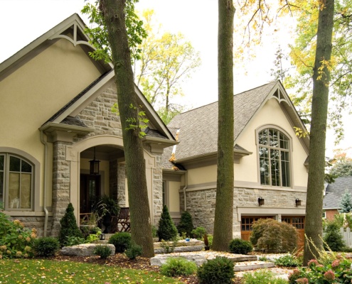 House renovation with stone siding, stucco and beige trim.