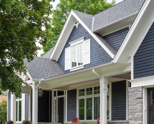 Mississauga home with wood siding, white shutters and stone steps.