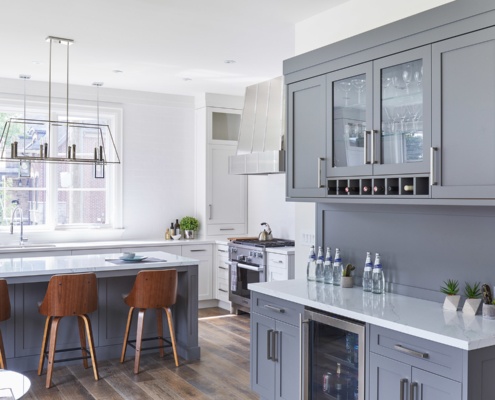 Kitchen with breakfast bar, white countertops and white frame window.