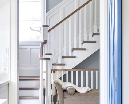 Home interior with white stair and blue barn door.