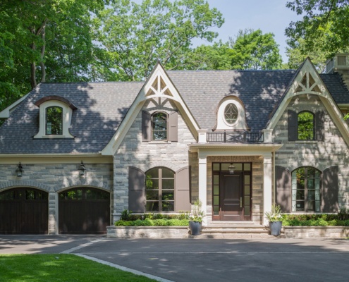 Traditional house with shutters, gables and wood front door.