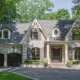 Traditional house with shutters, gables and wood front door.