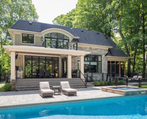 Transitional home with ntural stone, arched window and black frame windows.