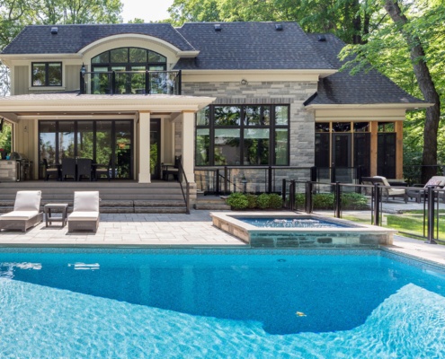 Covered patio with wood soffit, dark dining table and wood siding.