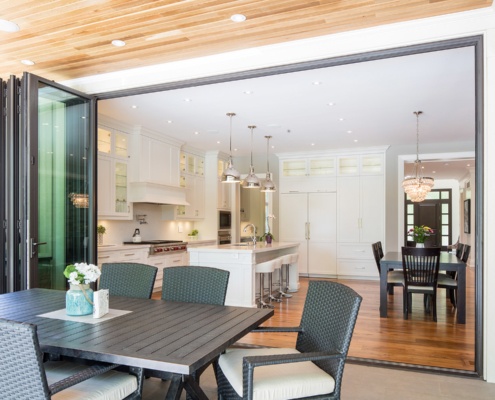 Open concept kitchen with white trim, hard wood flor and large wood table.