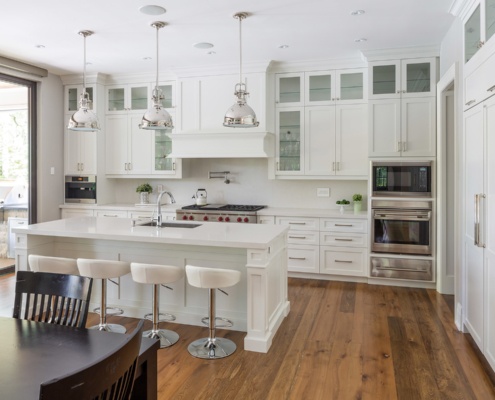 Traditional kitchen with white cabinets, white island and stainless steel applicance.