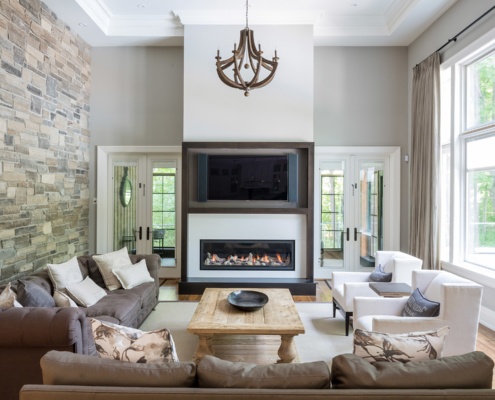 Family room with wood chandelier, built in fireplace and white frame windows.