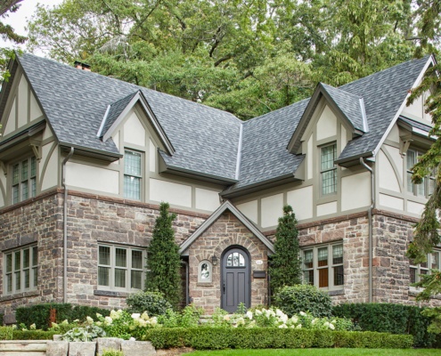 Front elevation with gables, shingled roof and beige frame windows.