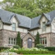 Front elevation with gables, shingled roof and beige frame windows.