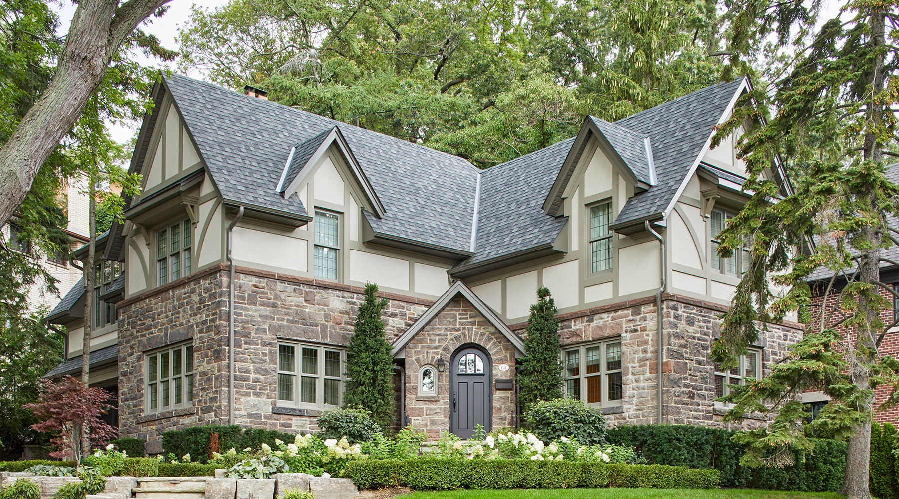 Front elevation with gables, shingled roof and beige frame windows.