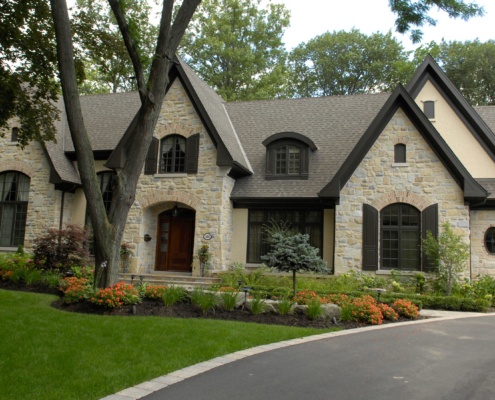 Mississauga home with stucco siding, wood front door and brick.