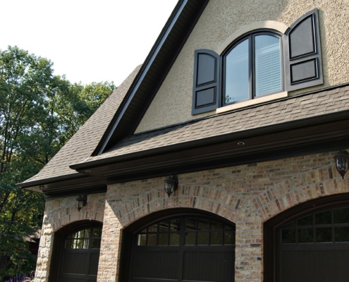 Custom home design with brick, shutters and black trim.
