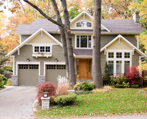 Traditional architecture with gabled roof, stone chimney and window box.