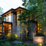 Modern house with steel beams, wood soffit and black frame windows.