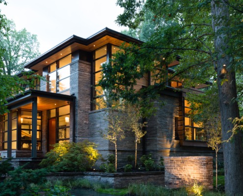 Modern house with steel beams, wood soffit and black frame windows.