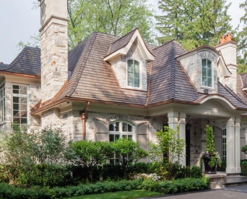 Custom home with white frame windows, white columns and copper detailing.